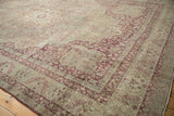 Intricate corner spandrel in raspberry red on a distressed antique Kerman with a time-softened patina.