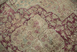 Worn pile of a distressed Kerman carpet reveals raspberry florals and the hand-knotted foundation.