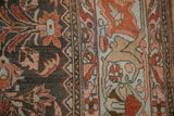 Distressed Lilihan carpet: close-up of fluid border, floral motifs, charcoal, terra cotta, and abrashes.