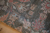 Distressed Lilihan rug detail highlighting worn charcoal pile, faded florals, and visible foundation threads.