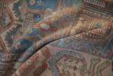 Folded vintage distressed Bakhtiari carpet with intricate garden motifs, sky blue, ruby red, and worn pile.