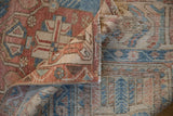 Distressed Bakhtiari carpet fold reveals even wear, hand-knotted foundation, and machine-bound side.