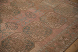 Angled view of the low pile texture on a distressed Ersari carpet with abrashed blush tones and guls.