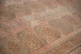 Angled view of the worn pile and geometric guls on a vintage blush pink Ersari carpet.