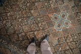 Close-up of distressed Joshegan carpet pile, with sapphire blue and peach botanical motifs.