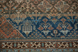 Distressed vintage Joshegan rug detail: sapphire blue field, tree of life motifs, and madder red border.