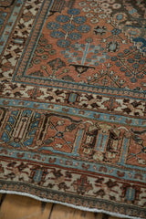 Intricate blue and ivory borders of the distressed Joshegan rug's madder root red field.