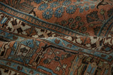 Textured distressed Joshegan rug, terracotta field, powder blue shrubs, and dark brown motifs.