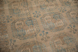 Distressed vintage Ersari carpet with softened pile, abrashed sand, and dusty blue guls.