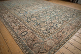 Vintage distressed Malayer carpet corner with faded teal field and pale coral palmette border.