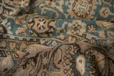 Distressed pile of vintage Malayer carpet showing dusty teal and brown floral vine motifs.