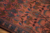 Intricate floral vines and palmettes in blue and olive on a plush raspberry red pile.