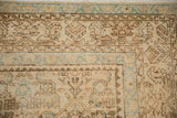 Distressed vintage Hamadan rug corner, highlighting geometric blossomed border motifs and fringe.
