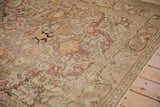 Distressed Kayseri carpet with faded brick red, sand, and pale mauve floral vine patterns.