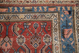Corner of a vintage Kurdish Hamadan carpet showing the playful floral blossom border.