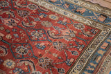 Saturated cherry red Herati field and sky blue floral border of a vintage Kurdish Hamadan carpet.