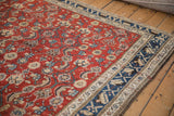 Thick pile and playful floral blossom border of a vintage Kurdish Hamadan carpet with a red Herati design.