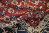 A folded view of the vintage Kurdish carpet showing its thick pile and floral motif.