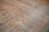 Distressed antique Persian Doroksh carpet, faded Herati design, soft blue and red tones, exposed foundation.