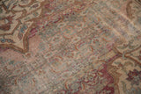 Antique distressed Doroksh carpet's worn texture, revealing foundation and faded floral arabesques.