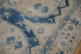 Distressed texture with blue geometric trellis and germinating bud motifs on vintage Bakhtiari carpet.