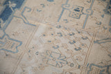 Distressed vintage Bakhtiari carpet detail with ivory, dusty blue trellis, and buds.