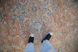 Overhead view showing the even wear and soft texture of a distressed vintage Heriz carpet.