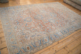 Angled perspective on a vintage Heriz rug, showing the abrashed sandalwood field and central medallion.