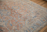 Angled view of the distressed low pile on a Heriz rug with sky blue and sandalwood floral vinery.