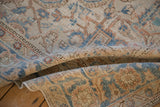 A soft fold revealing the distressed texture and low pile of a vintage Heriz carpet.