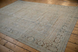 Distressed Persian Mahal rug corner with worn field pattern, beige tones, and bound edge.