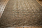 Distressed texture and rhythmic geometric border patterns of the vintage Bokhara rug.