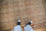 A look at the distressed texture and even wear on a vintage Qom carpet with columns of boteh motifs.
