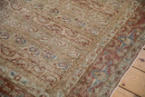 Distressed Qom carpet corner showing repeating boteh columns and a chestnut palmette border.