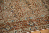 Low-pile texture on the chestnut border with floral palmettes and the repeating boteh field.