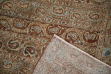 Corner view of a distressed Qom carpet showing its worn boteh pile and hand-knotted reverse.