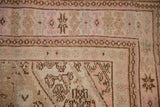 Evenly worn, low pile texture on a Bibikabad corner with pink, beige, and chocolate brown motifs.