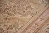 A close view of the worn, hand-knotted pile and Herati motif on a distressed pink Bibikabad carpet.