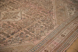 A distressed overdyed carpet's corner spandrel showing Herati motifs in bubblegum pink and dusty slate blue.