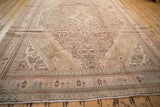 Full length perspective view of a vintage distressed Bibikabad carpet showing its low pile and faded pink design.