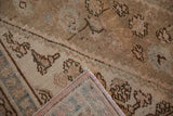 Folded corner of a distressed Bibikabad rug showing the low pile and hand-knotted foundation.