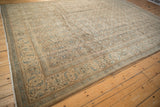 Angled view of a vintage Mahal carpet with an allover Herati design in soft neutral tones.