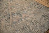 Evenly worn, low-pile corner of a vintage Joshegan carpet with dusty teal motifs.