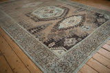 Distressed low pile revealing the beige, powder blue, and brown patterns of a vintage Persian carpet.
