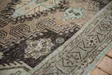 Low-pile texture and distressed character of a vintage carpet in brown and powder blue.