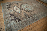 The geometric border in powder blue and brown on a distressed Veece carpet with a low, worn pile.