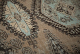 Angled detail of a vintage Persian carpet showing the distressed low pile and visible knot heads.