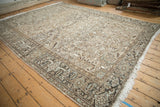 Distressed Vintage Heriz carpet corner, soft beige, brown, and muted blue patterns with even wear.
