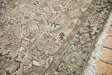 Distressed Heriz rug border with geometric turtle motifs, muted beige, brown, and teal, light fringe.