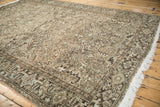 Distressed vintage Heriz rug corner: geometric motifs, palmettes, subtle abrashes, white fringe.